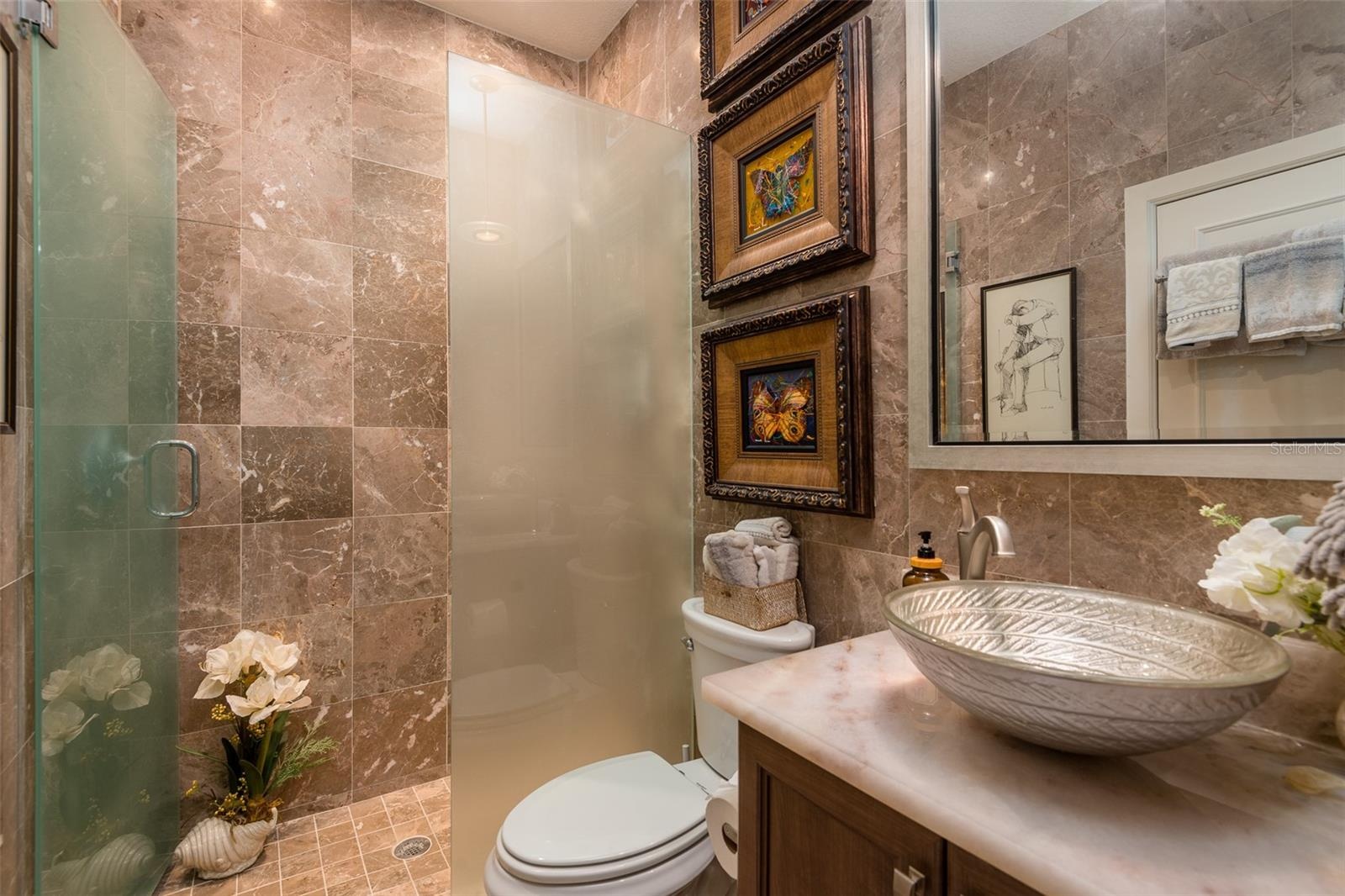 First floor full bath highlighting tile and quartz vanity top with bowl sink