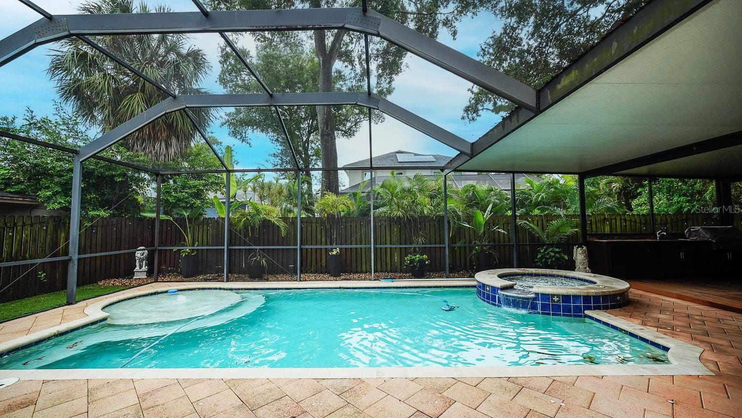 Full sized pool with spa and walk-in pool sunbath area.