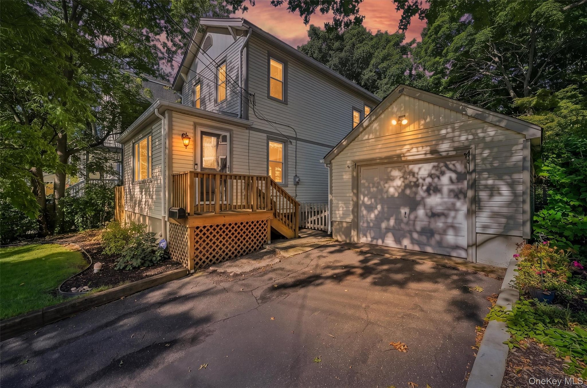 Twilight view of front. Including the detached garage and driveway