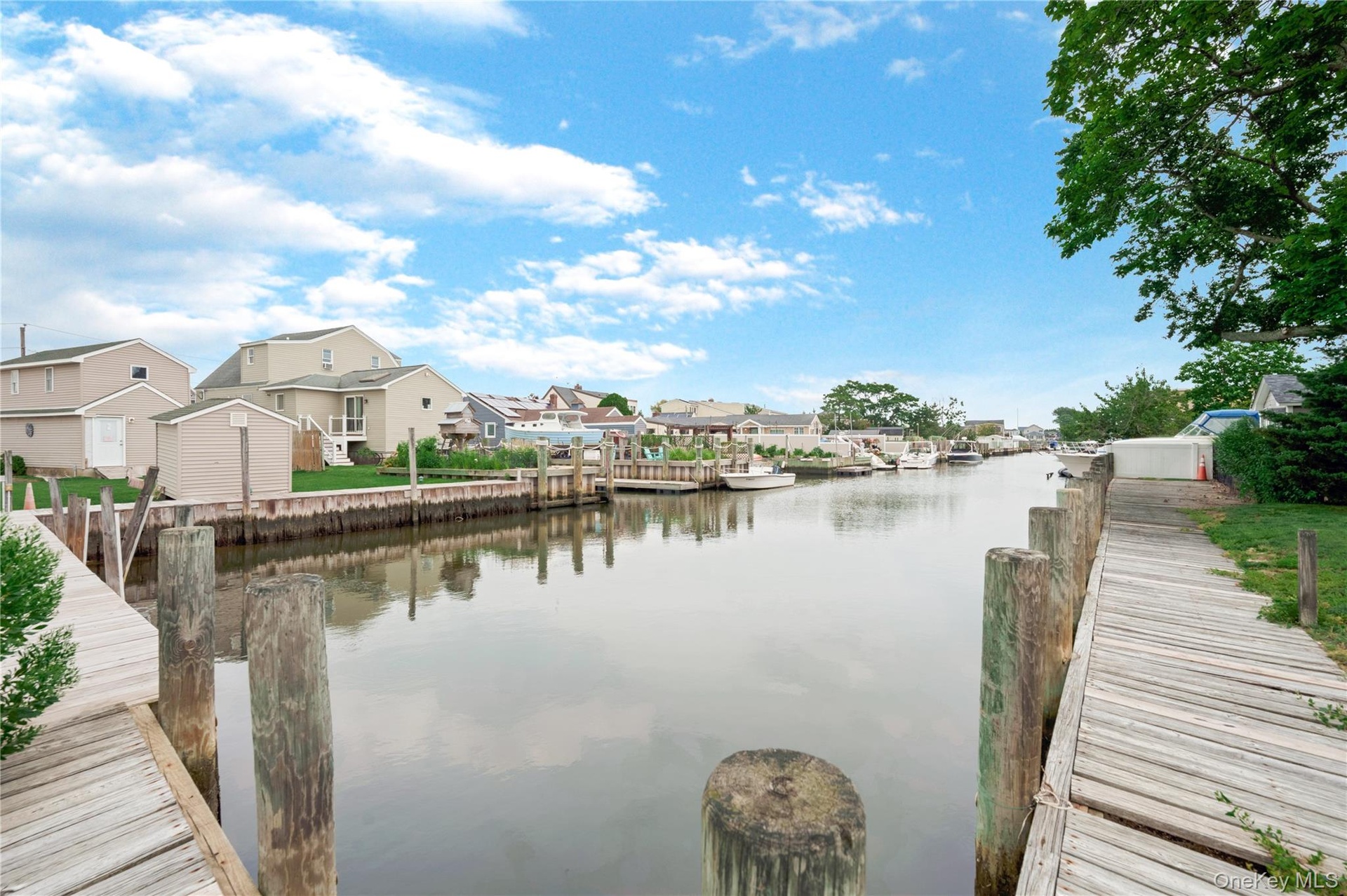 Waterfront property with extensive wooden dockage, mature trees, and canal access