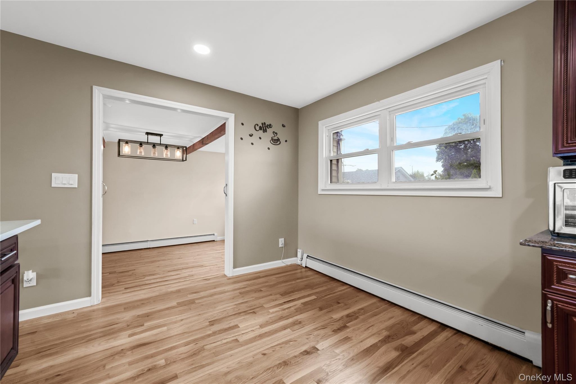 Wood-finish flooring, recessed lighting, and a window with trim