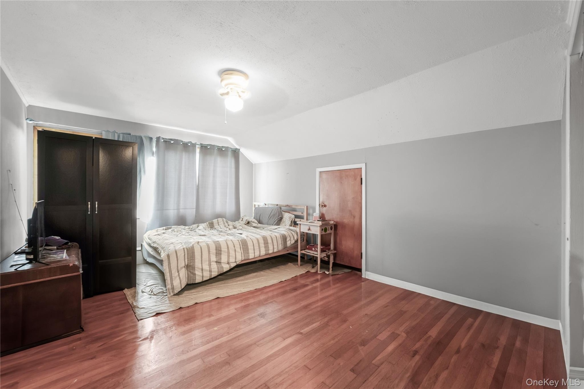 Hardwood flooring, painted walls, and ceiling-mounted light fixture