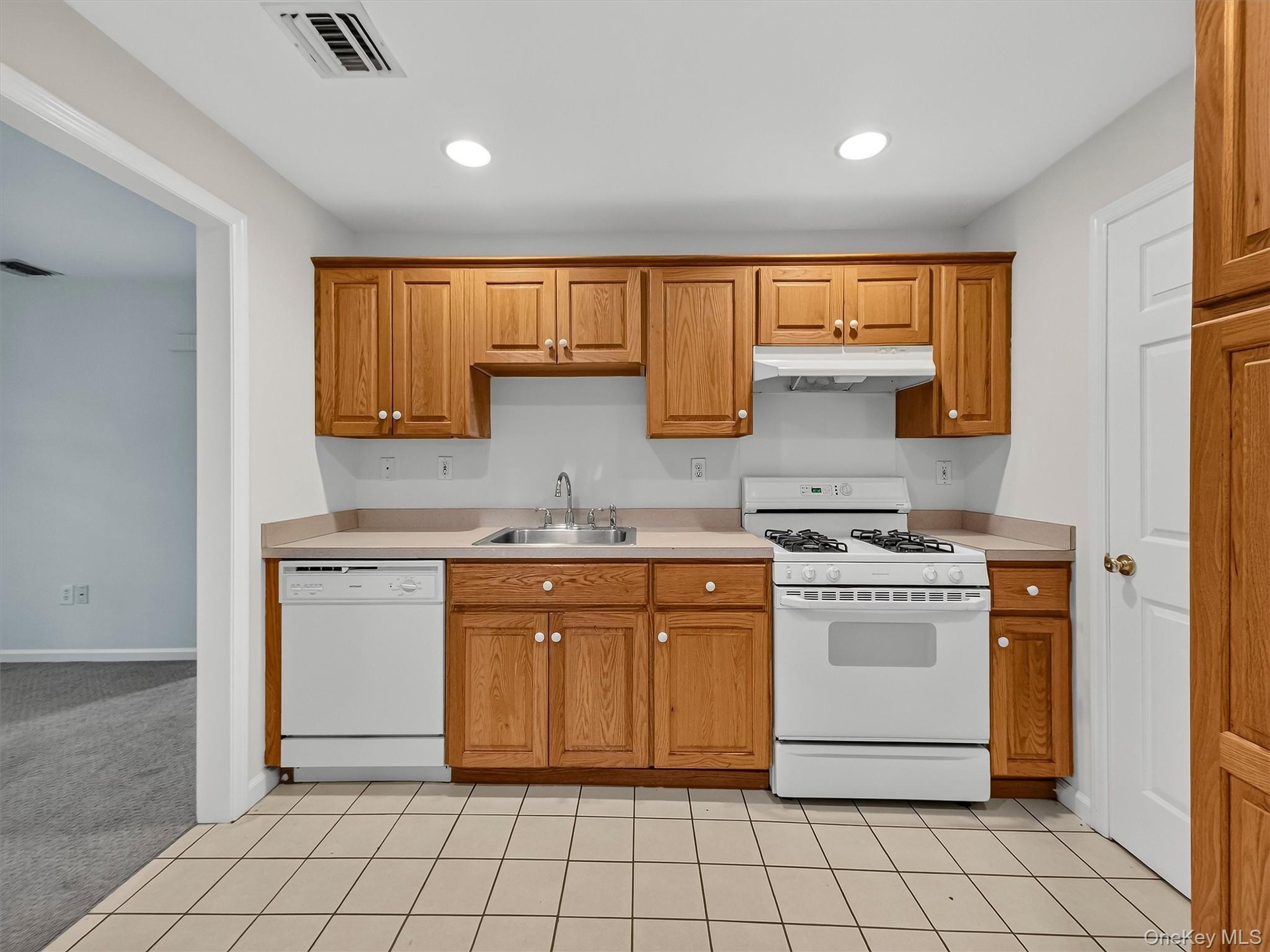 The finished lower level features a fully equipped summer kitchen with abundant cabinetry and workspace, adding exceptional flexibility for entertaini
