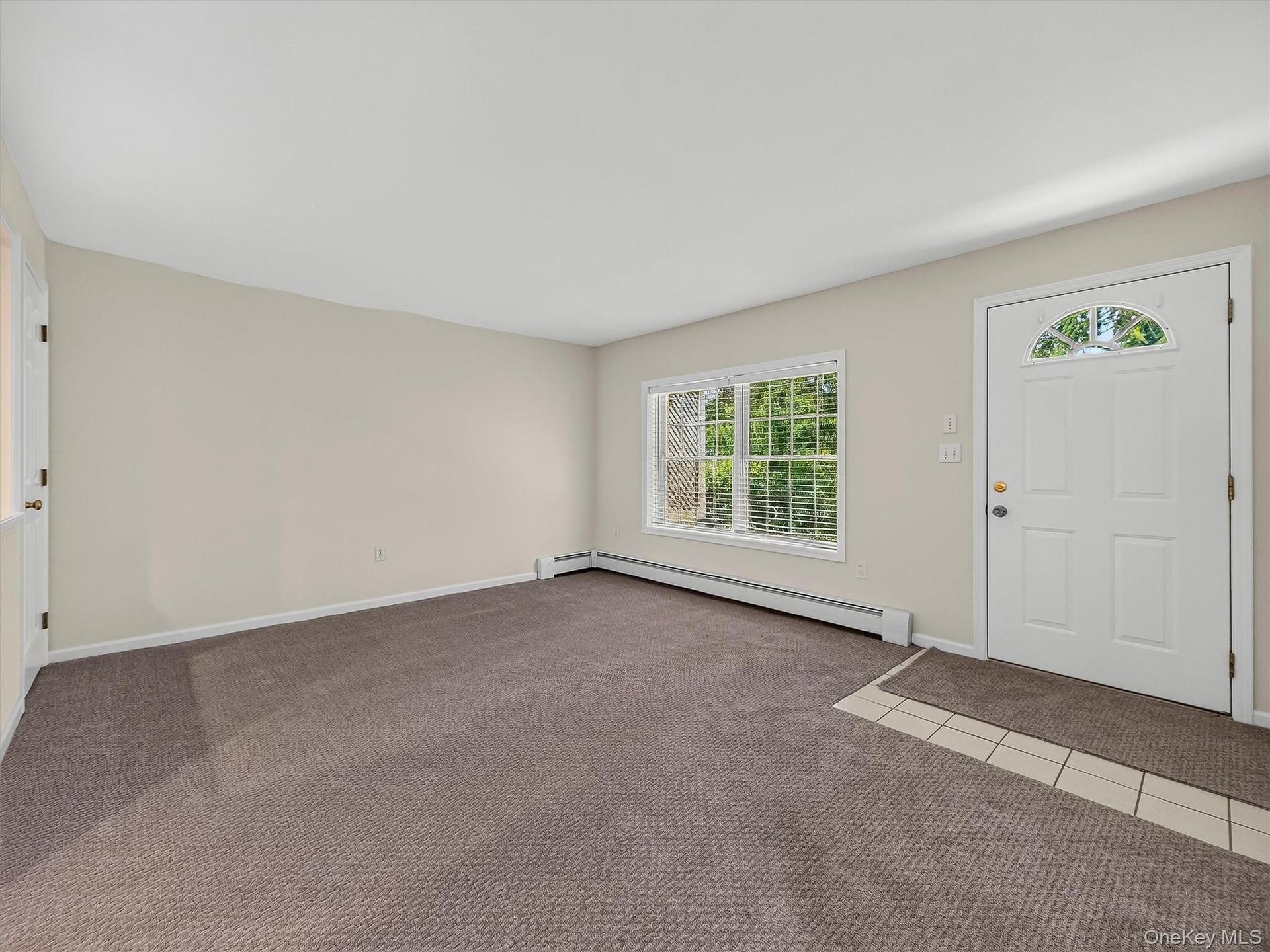 The expansive finished lower-level living area is filled with natural light and features its own exterior entrance, creating an exceptionally versatil