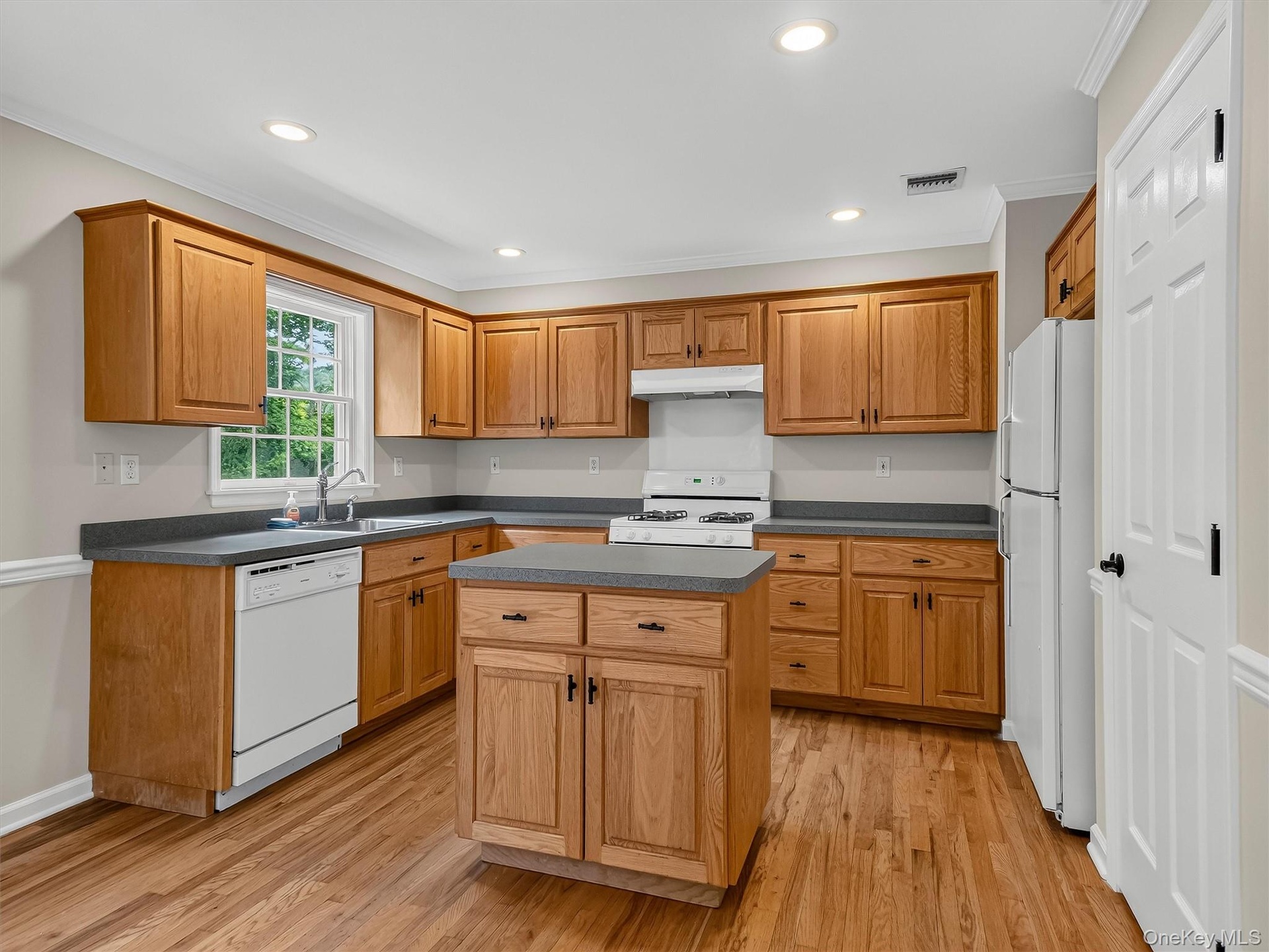 The thoughtfully designed kitchen offers abundant cabinetry, generous prep space, a center island, and a functional layout that makes everyday cooking