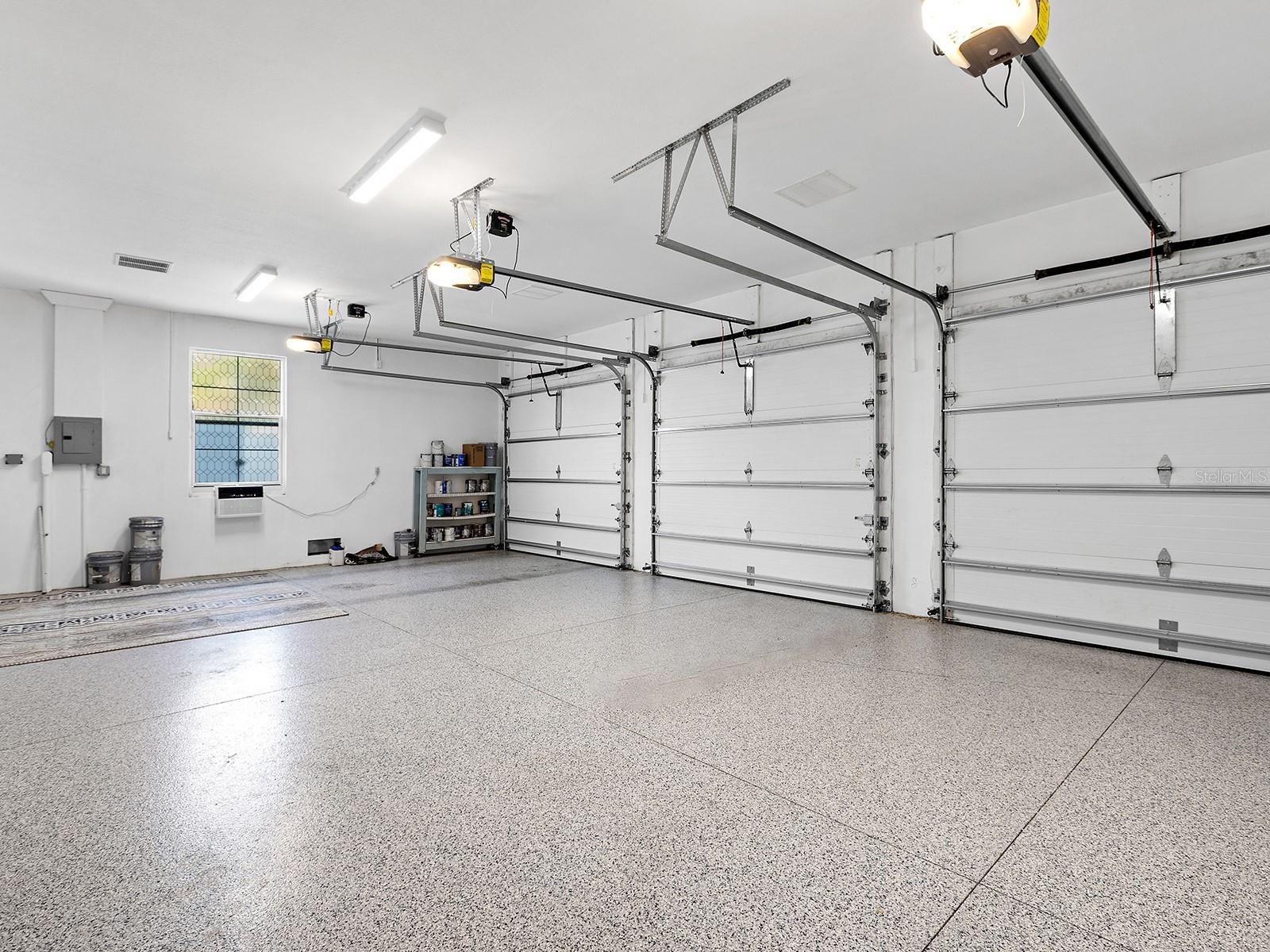 Oversized multi-car garage with epoxy flooring, high clearance for equipment, and built-in storage potential