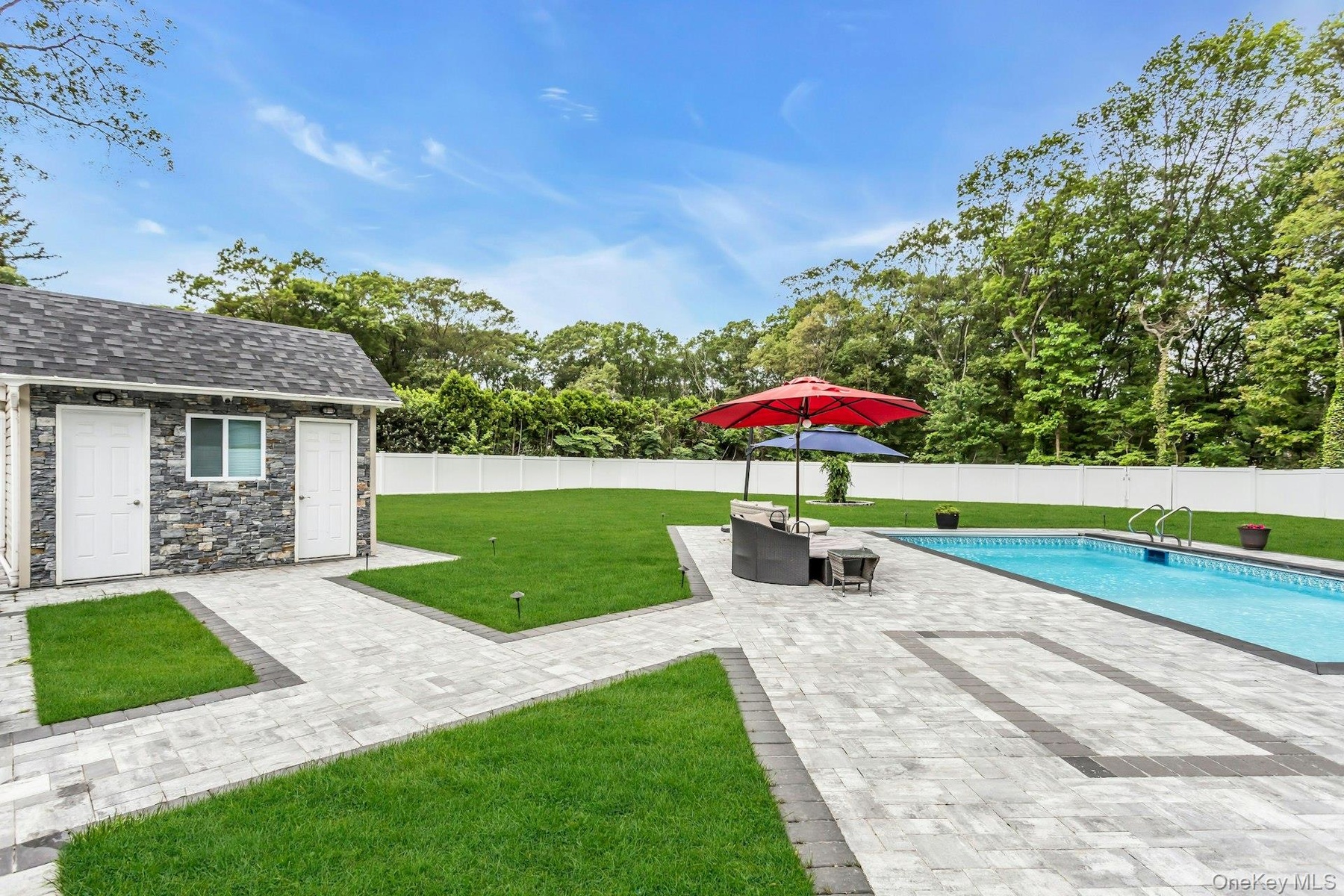 View of yard with a patio area, an outdoor structure, and view of wooded area