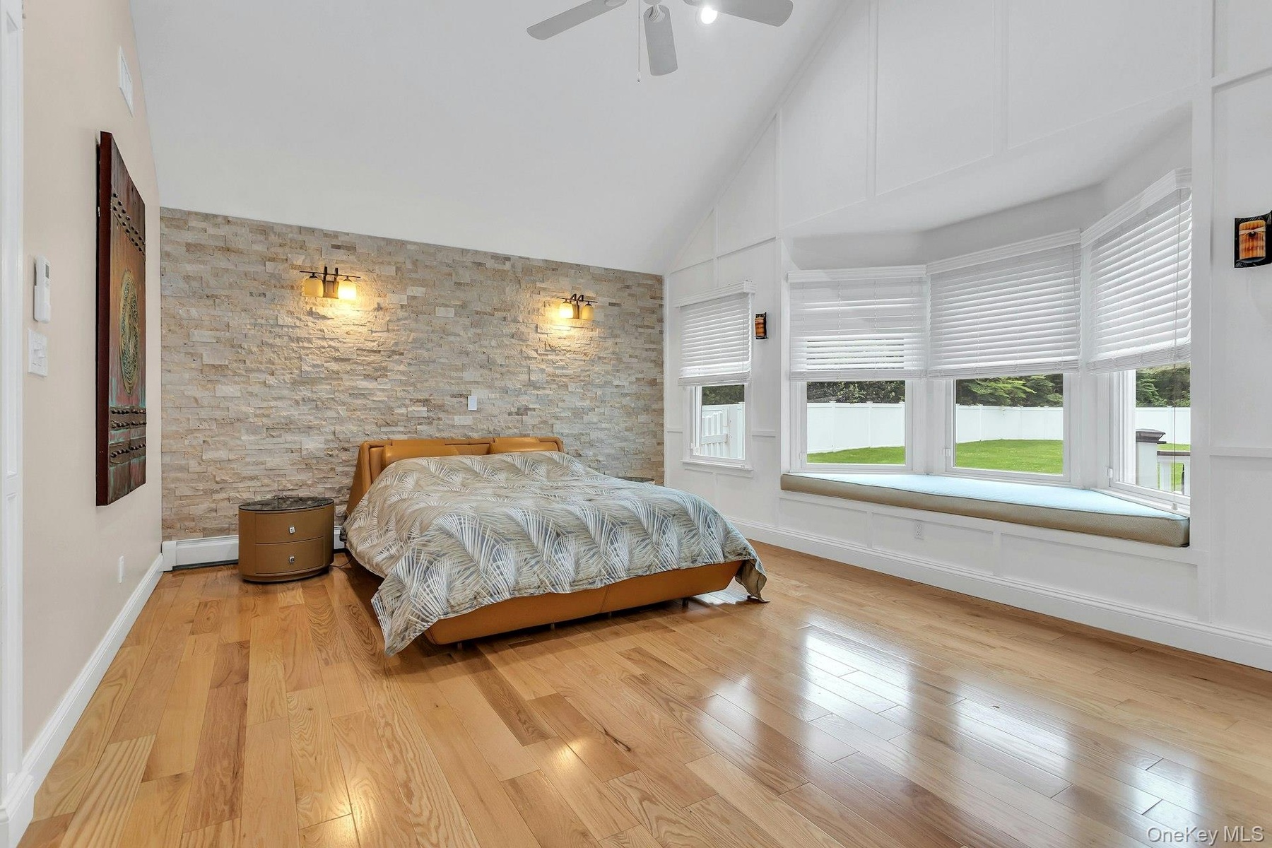 Bedroom with multiple windows, wood finished floors, high vaulted ceiling, and ceiling fan