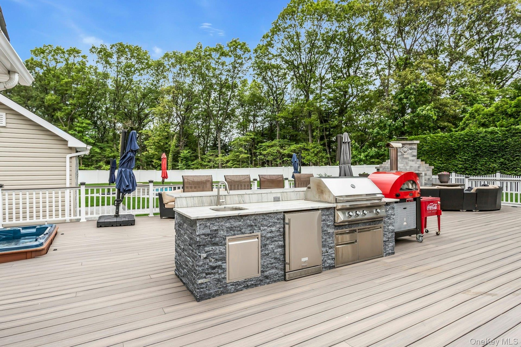 Deck featuring a sink, view of wooded area, and an outdoor living space