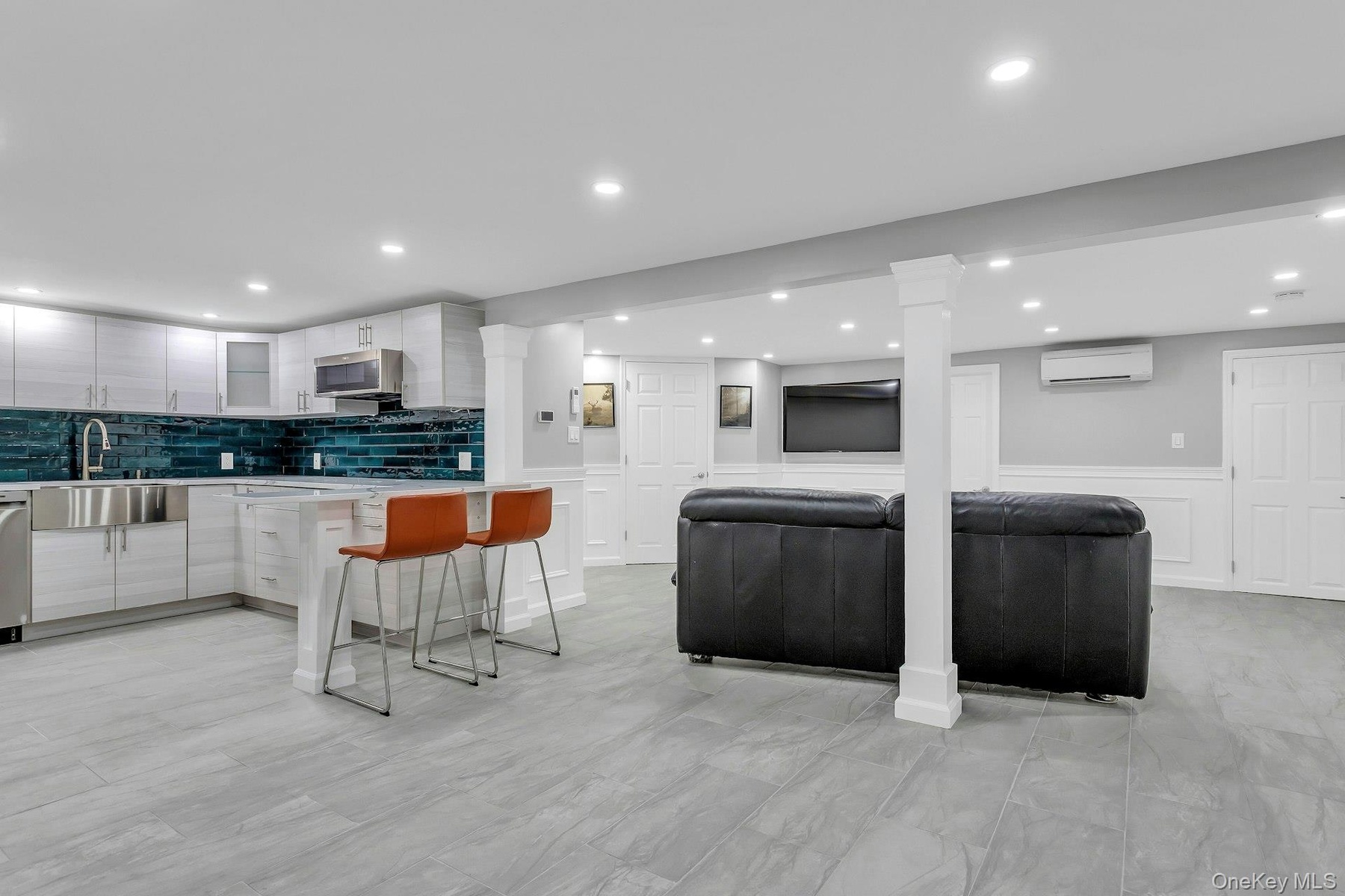 Kitchen featuring a sink, a wall unit AC, appliances with stainless steel finishes, light countertops, and modern cabinets