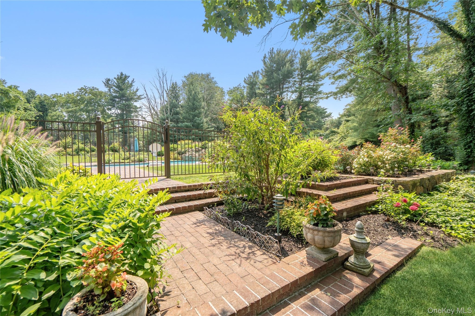 luscious landscaping leads to salt water pool and pool house