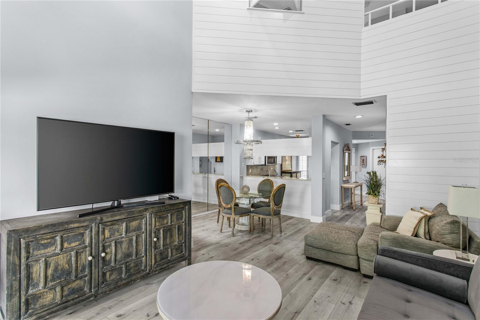 The two-story shiplap feature wall adds architectural interest and a warm focal point in the living room.
