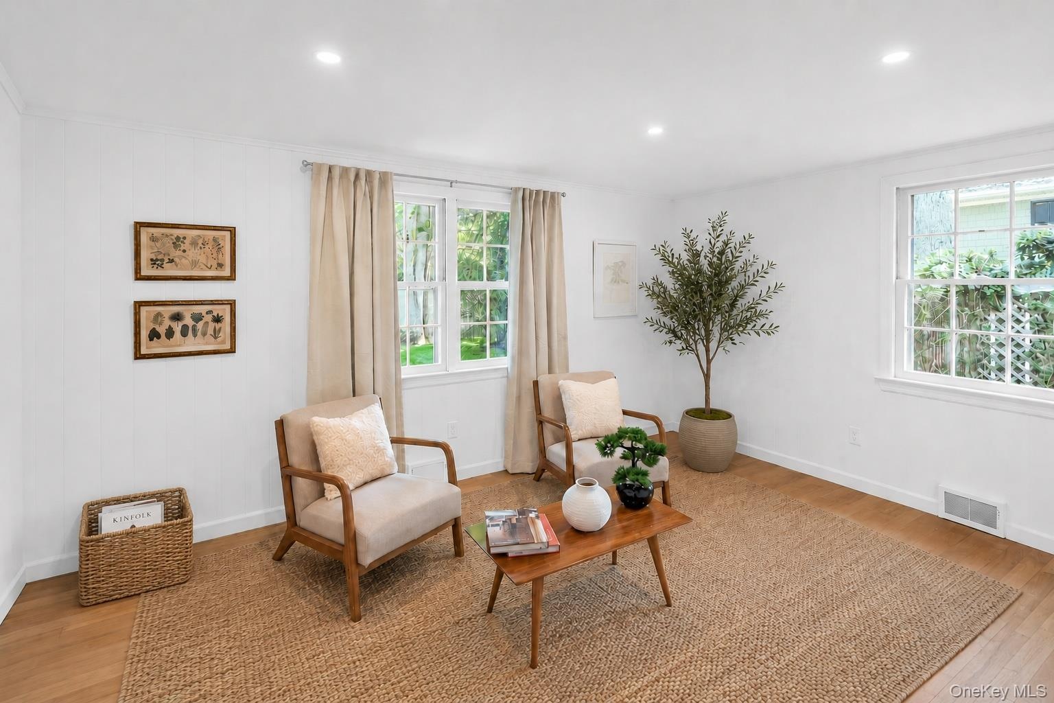 Recessed lighting, light wood-finish flooring, white walls, and multiple windows with white trim
