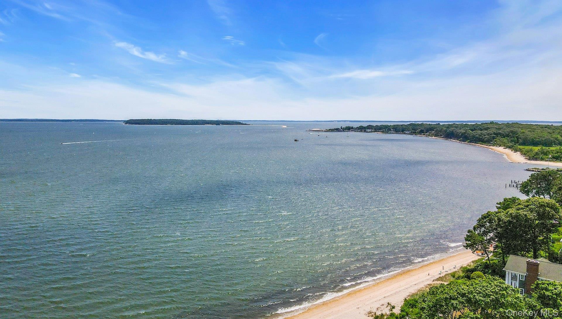 Expansive waterfront with a sandy beach and a distant island