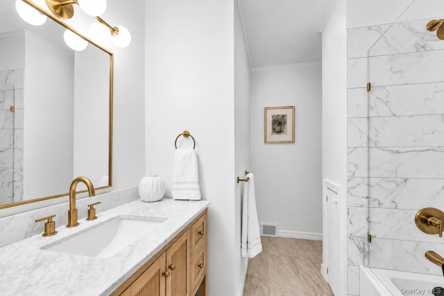 Modern vanity featuring an integrated rectangular sink and gold-tone fixtures
