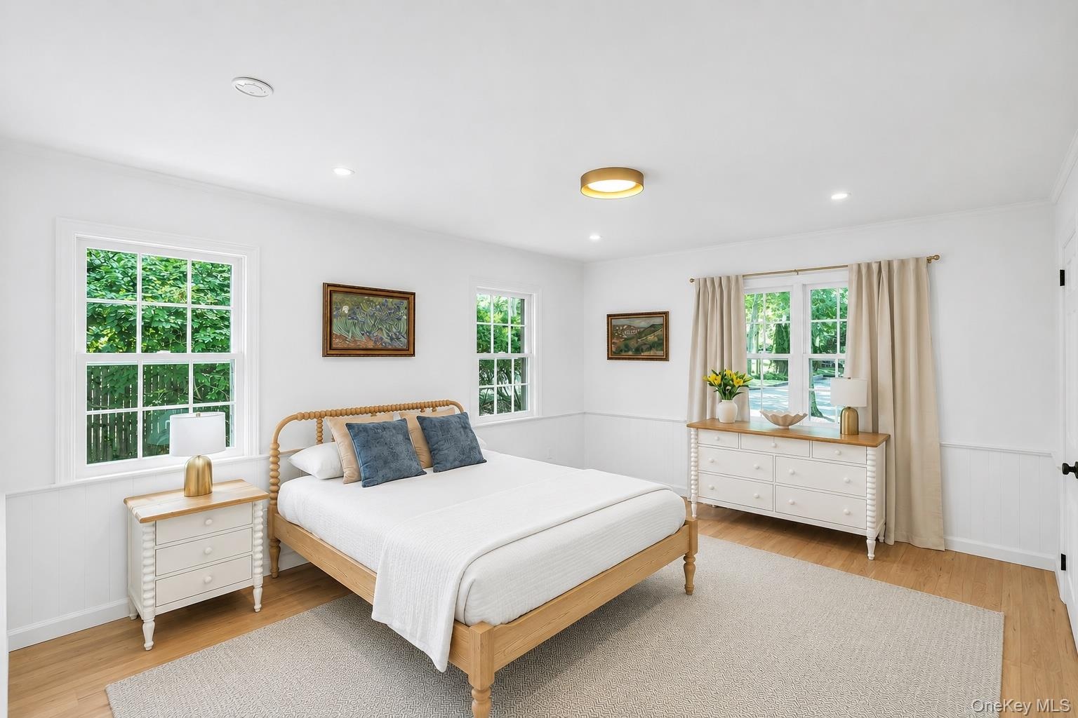 Wood-finish flooring, recessed lighting, and a circular flush-mount ceiling fixture