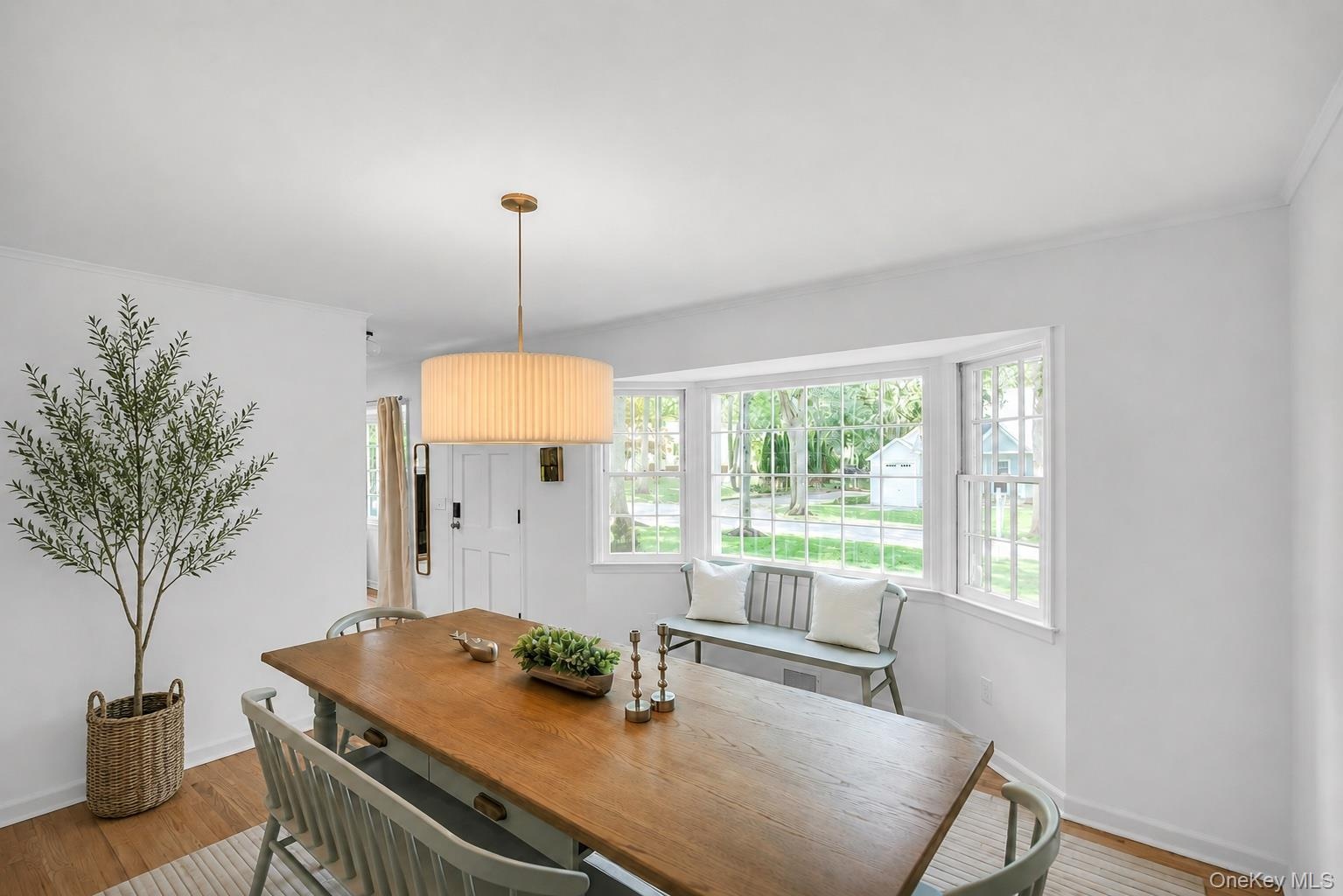 Hardwood-finish flooring, white walls, and a large bay window