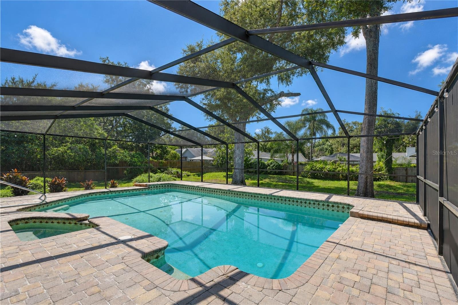 Spacious covered and screened outdoor living area overlooking the pool