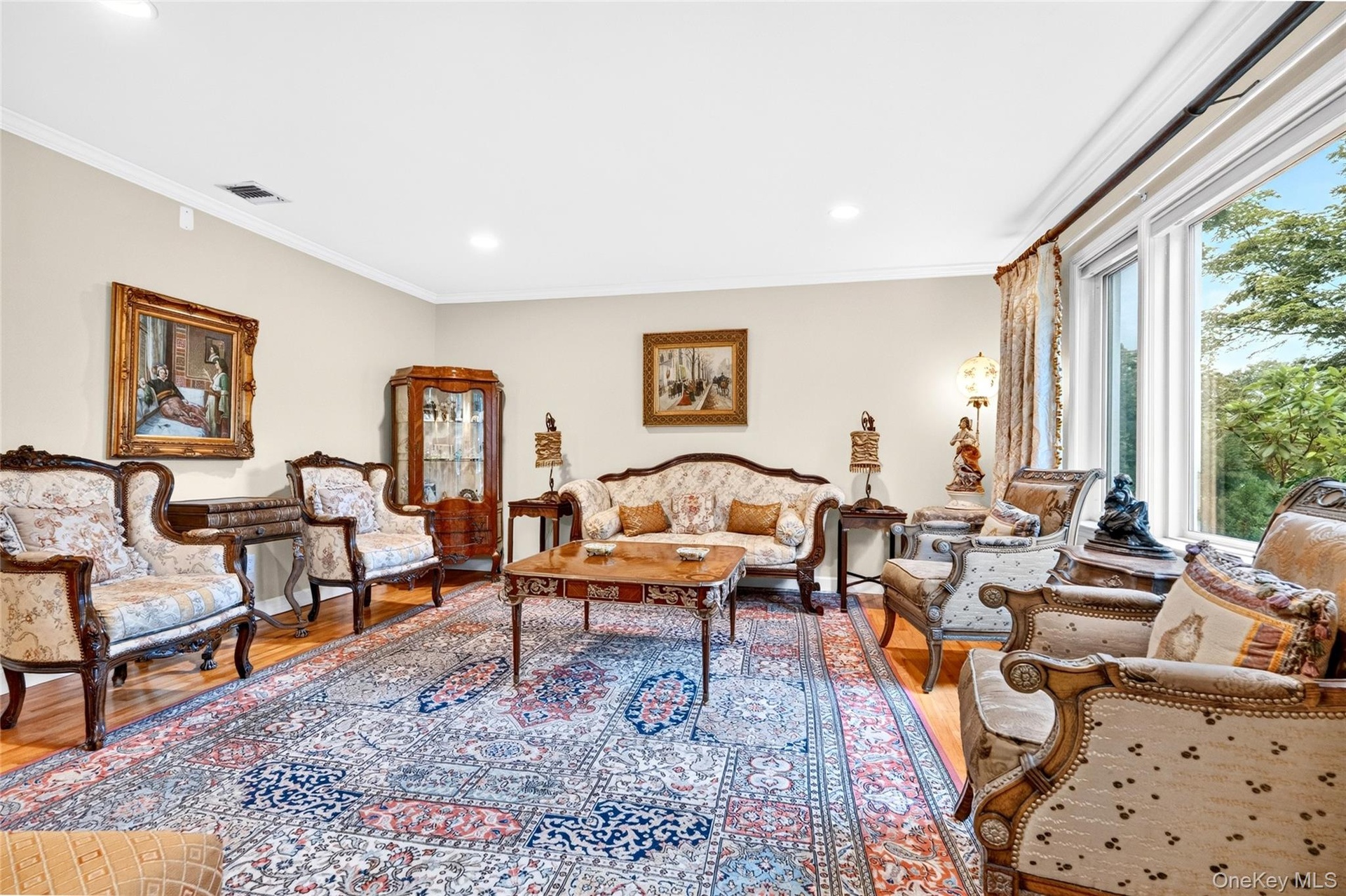 Hardwood flooring, recessed lighting, crown molding, and large windows