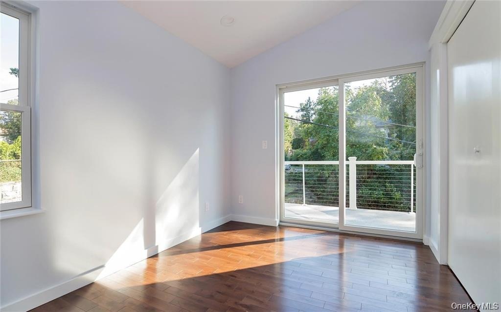 Spare room with lofted ceiling and wood finished floors