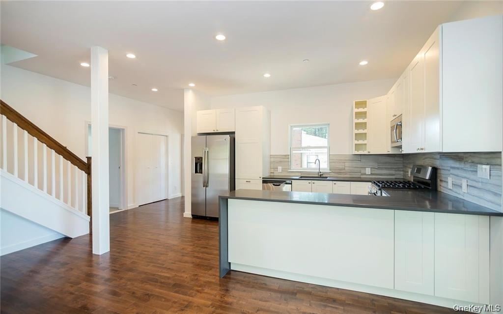 Kitchen featuring open shelves, appliances with stainless steel finishes, recessed lighting, tasteful backsplash, and white cabinets
