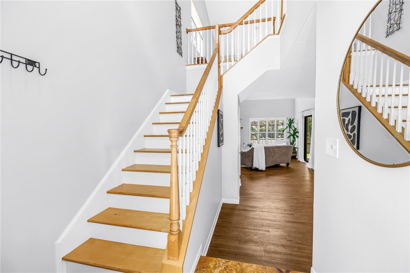 Open Feel for Stairs with light colored natural wood and soaring ceilings to the upstairs loft and office space