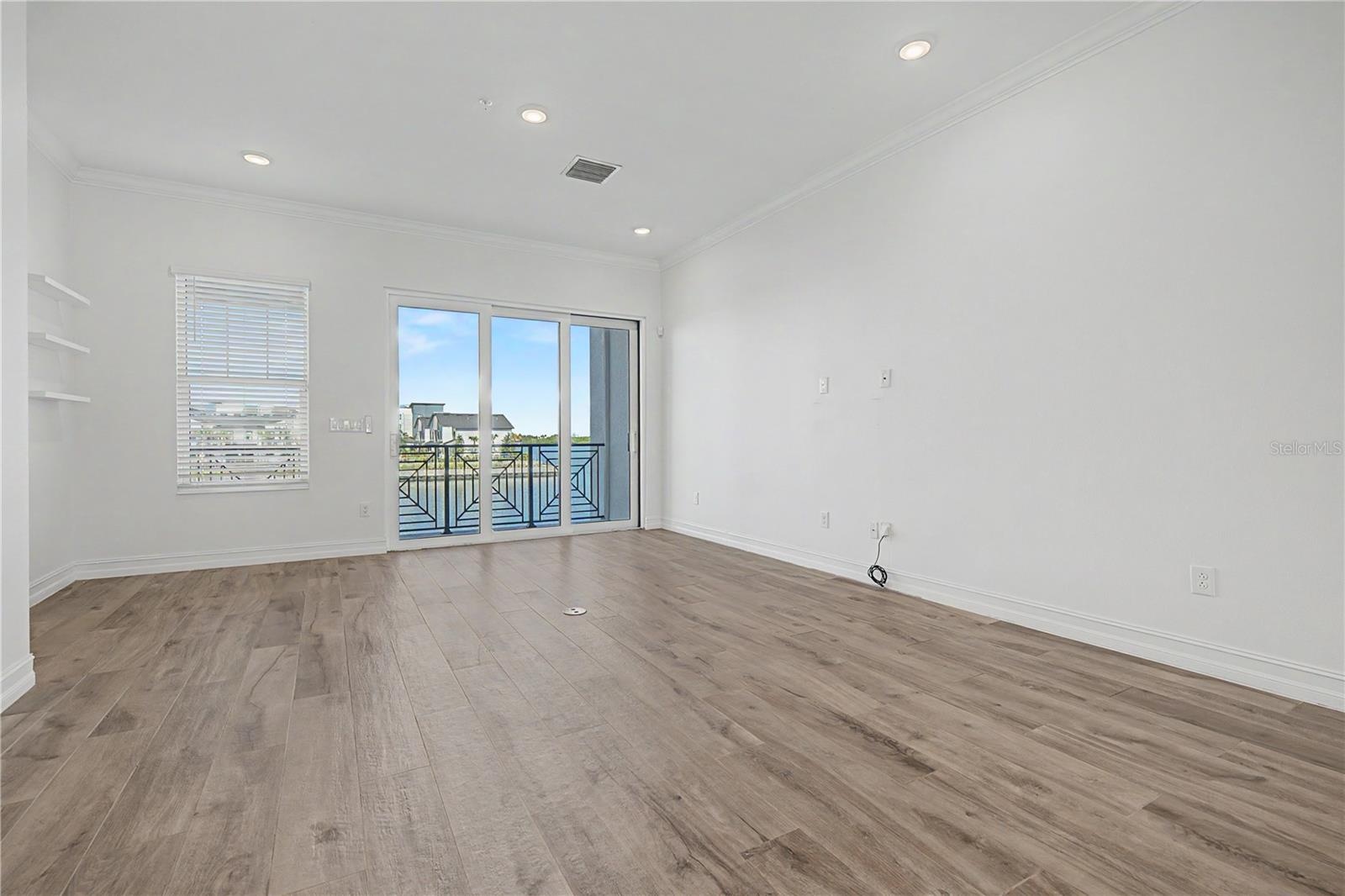 Second-level living area with a bright, open, and inviting feel straight to sliding doors that lead to an amazing outdoor patio.