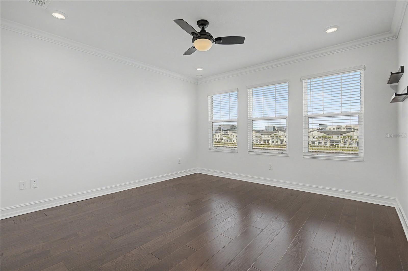 hird-level primary bedroom featuring a trio of west-facing windows that fill the space with natural light.