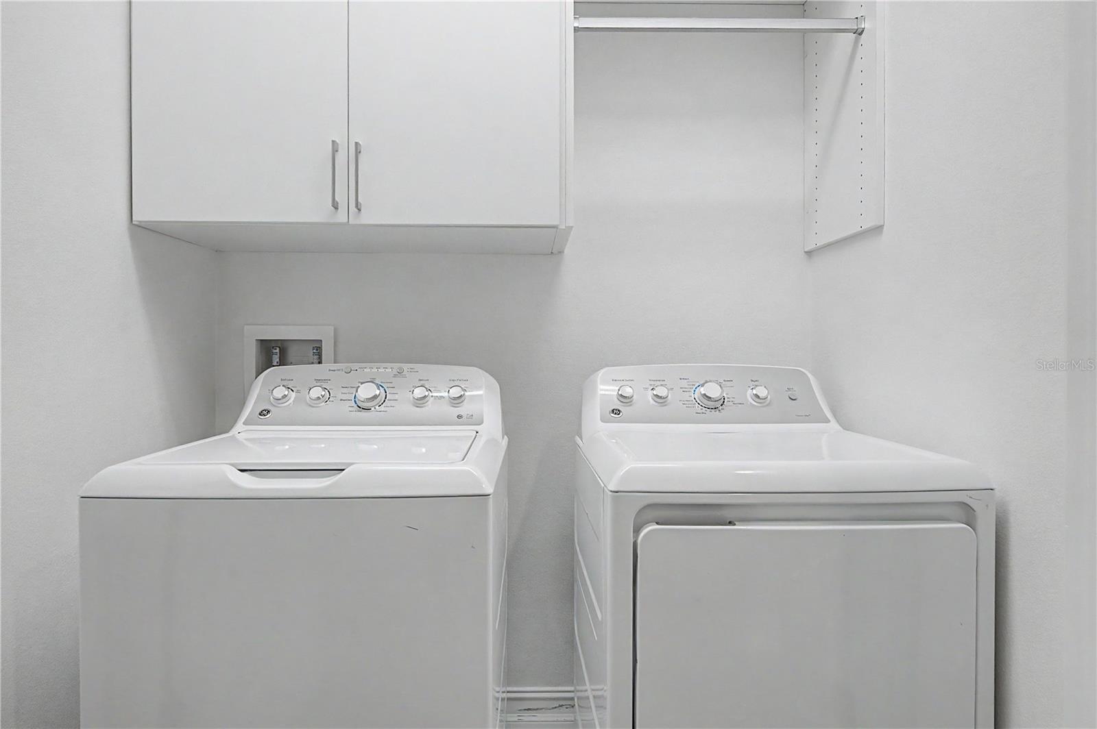 Third-level laundry room featuring high-efficiency washer and dryer connections with ample storage space.
