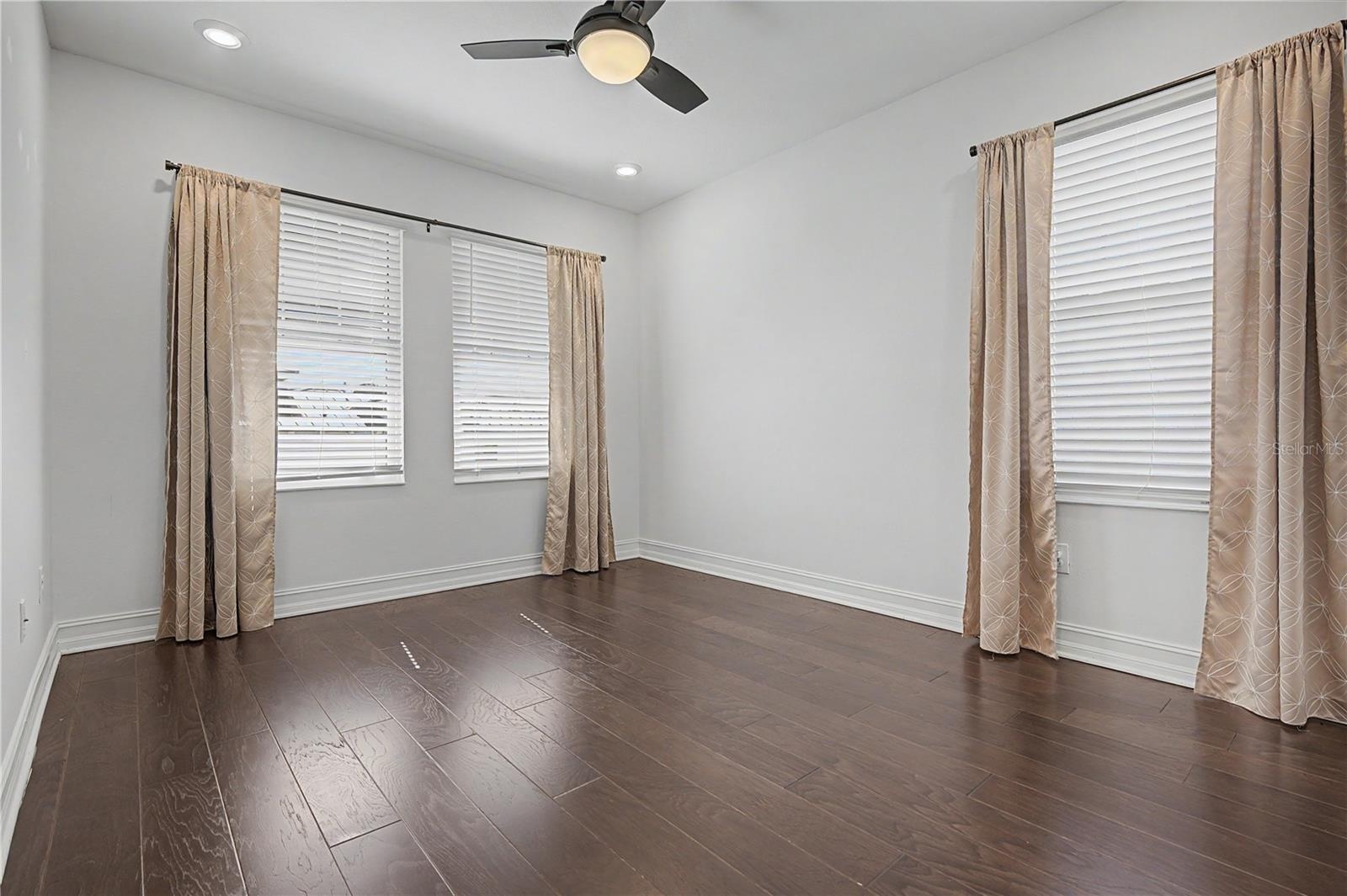 Third-level third bedroom featuring east- and south-facing windows for abundant natural light.