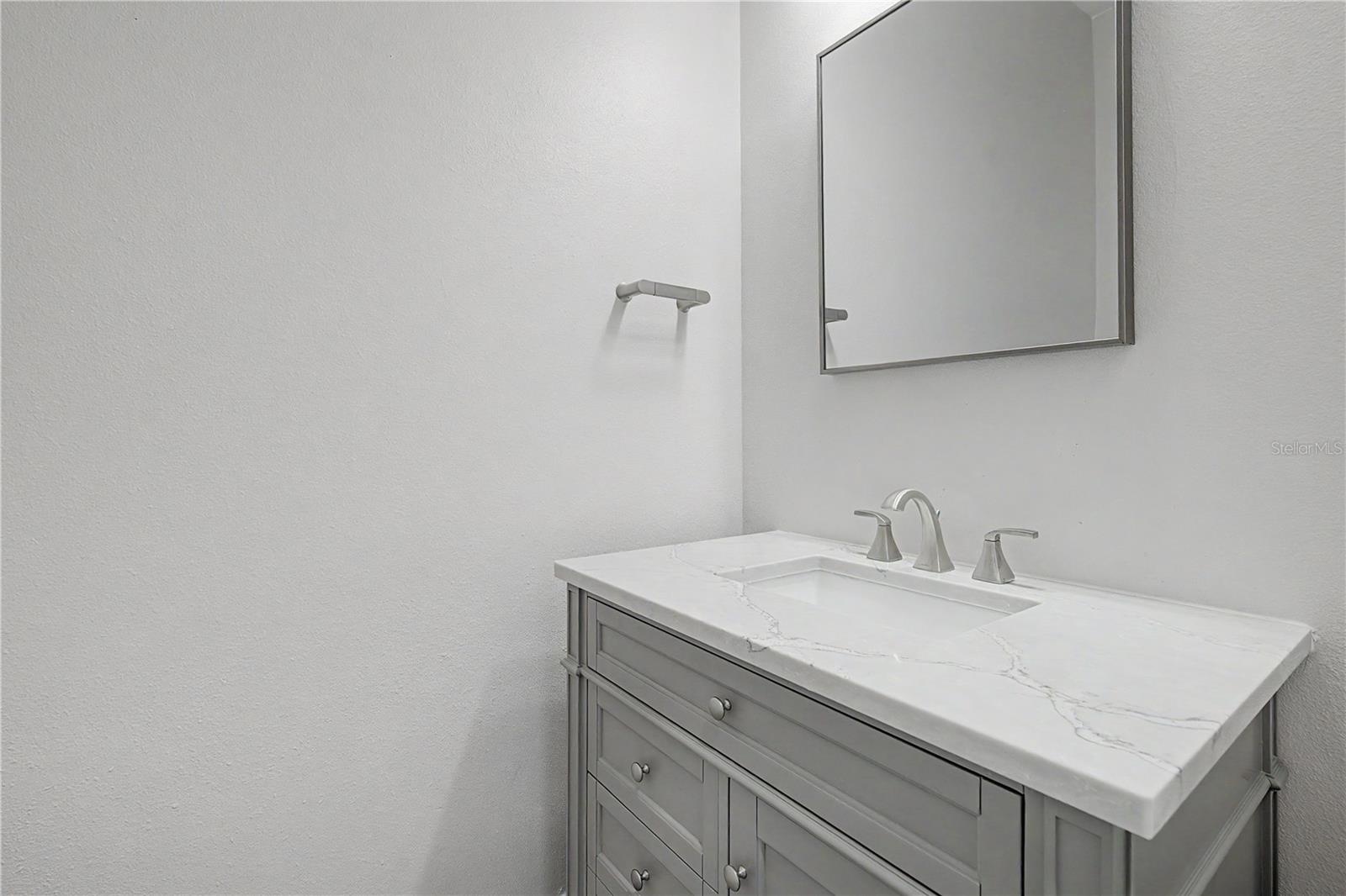 Second-level bathroom conveniently located in the hallway just off the living area, near the stairs leading to the third level.