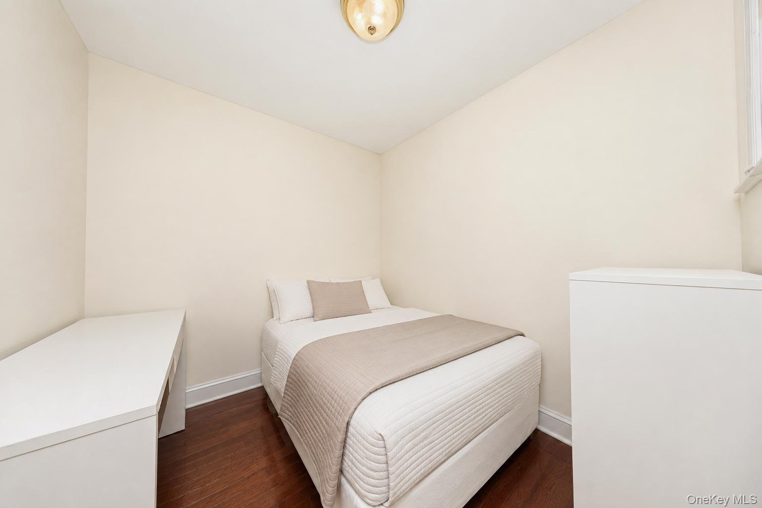 Warm neutral wall color, dark wood-finish flooring, and a flush mount ceiling light fixture