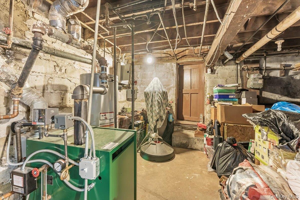Unfinished below grade area with a heating unit and water heater
