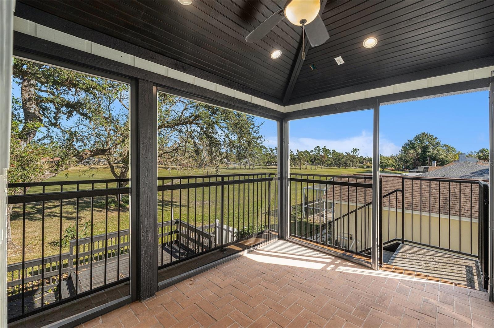 Screened lanai off of primary bedroom overlooking golf course