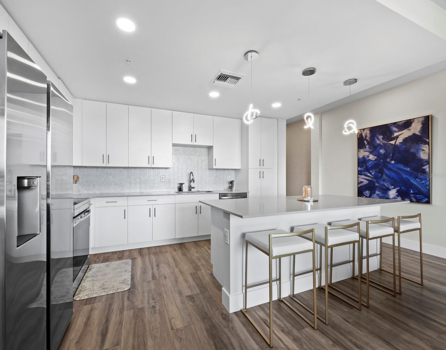 Luxury vinyl flooring & exquisite tile backsplash. Upgraded light fixtures over roomy breakfast bar