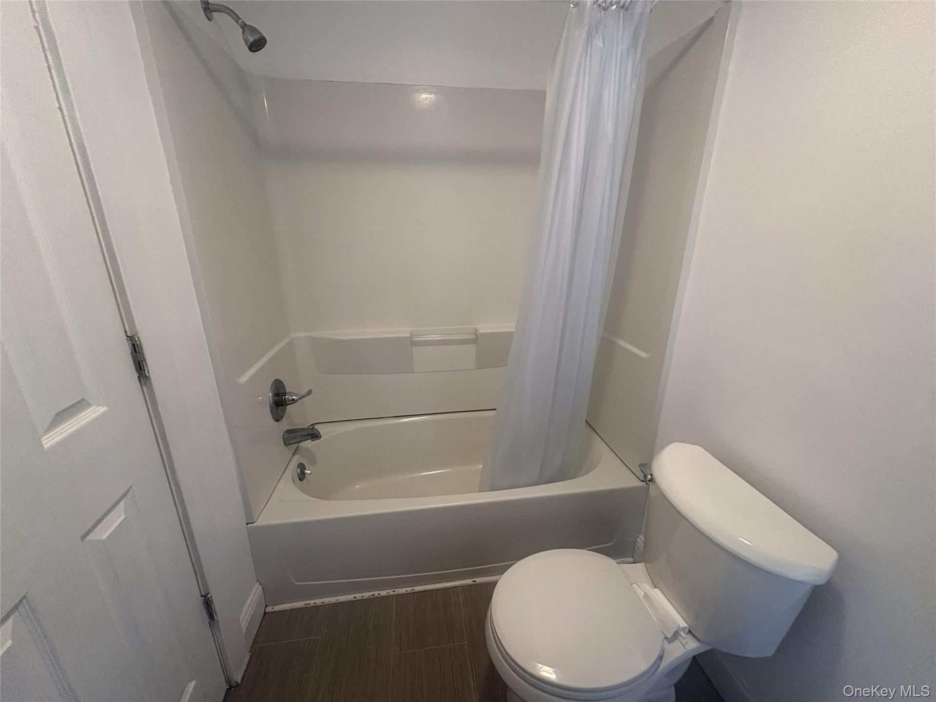 White tub and shower combination with chrome fixtures