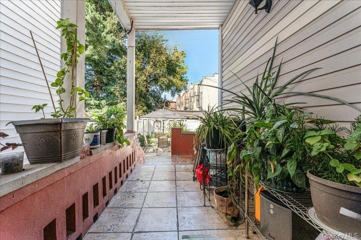 The covered backyard pathway features low-maintenance tiled flooring and plenty of space for potted plants and greenery. It offers a clear, comfortabl
