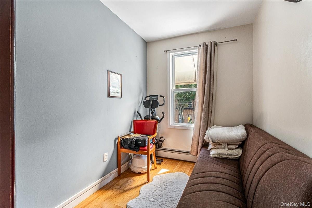 This cozy second-floor living space features warm hardwood floors, light blue accent walls, and a bright window. It is a highly versatile area that wo