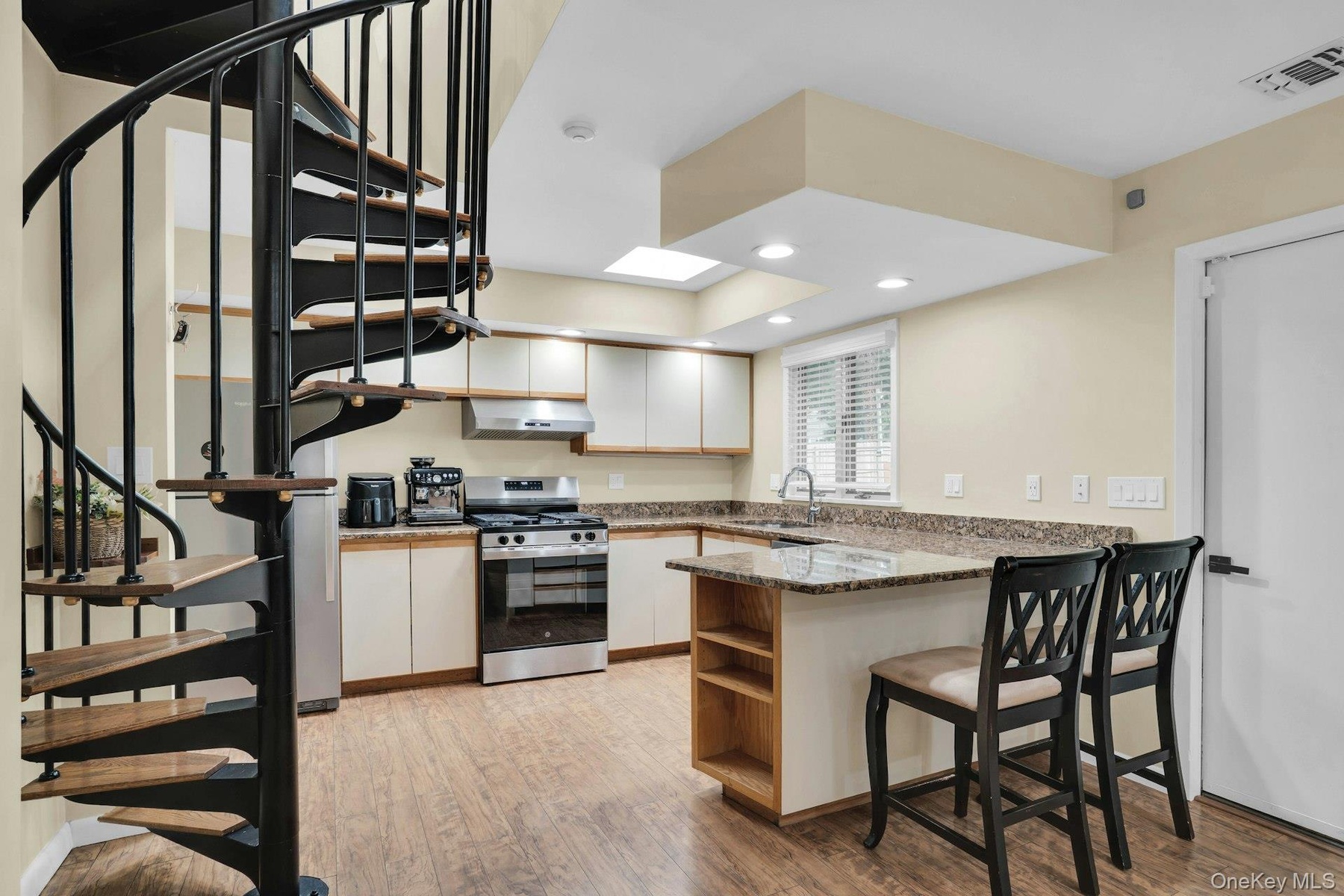 Spiral staircase leads to office or small bedroom.