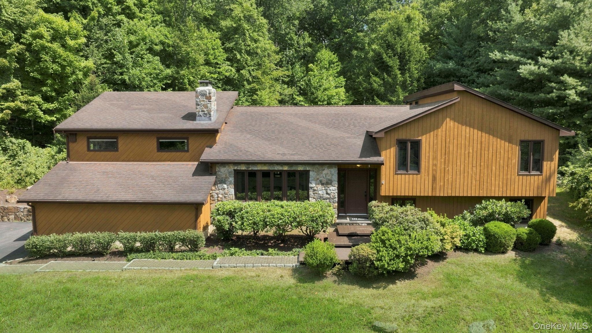 Wood-finish siding with stone accents and a stone chimney