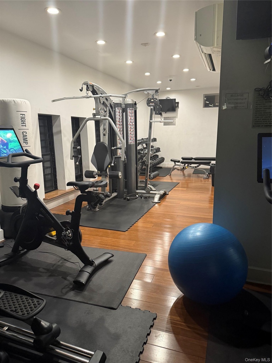 Gym featuring hardwood / wood-style floors and recessed lighting