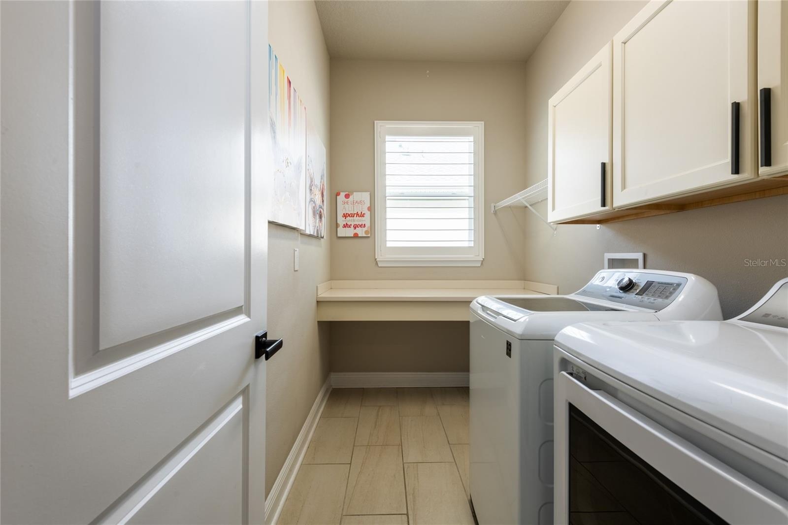 Spacious laundry room with storage and a folding shelf.