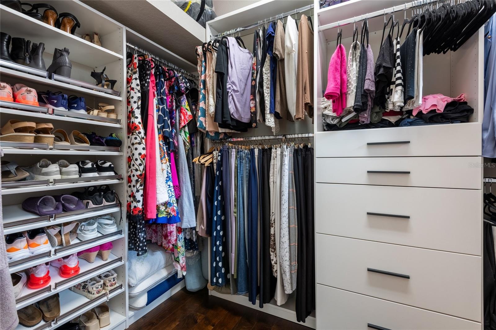 Spacious customized closet with soft close drawers.