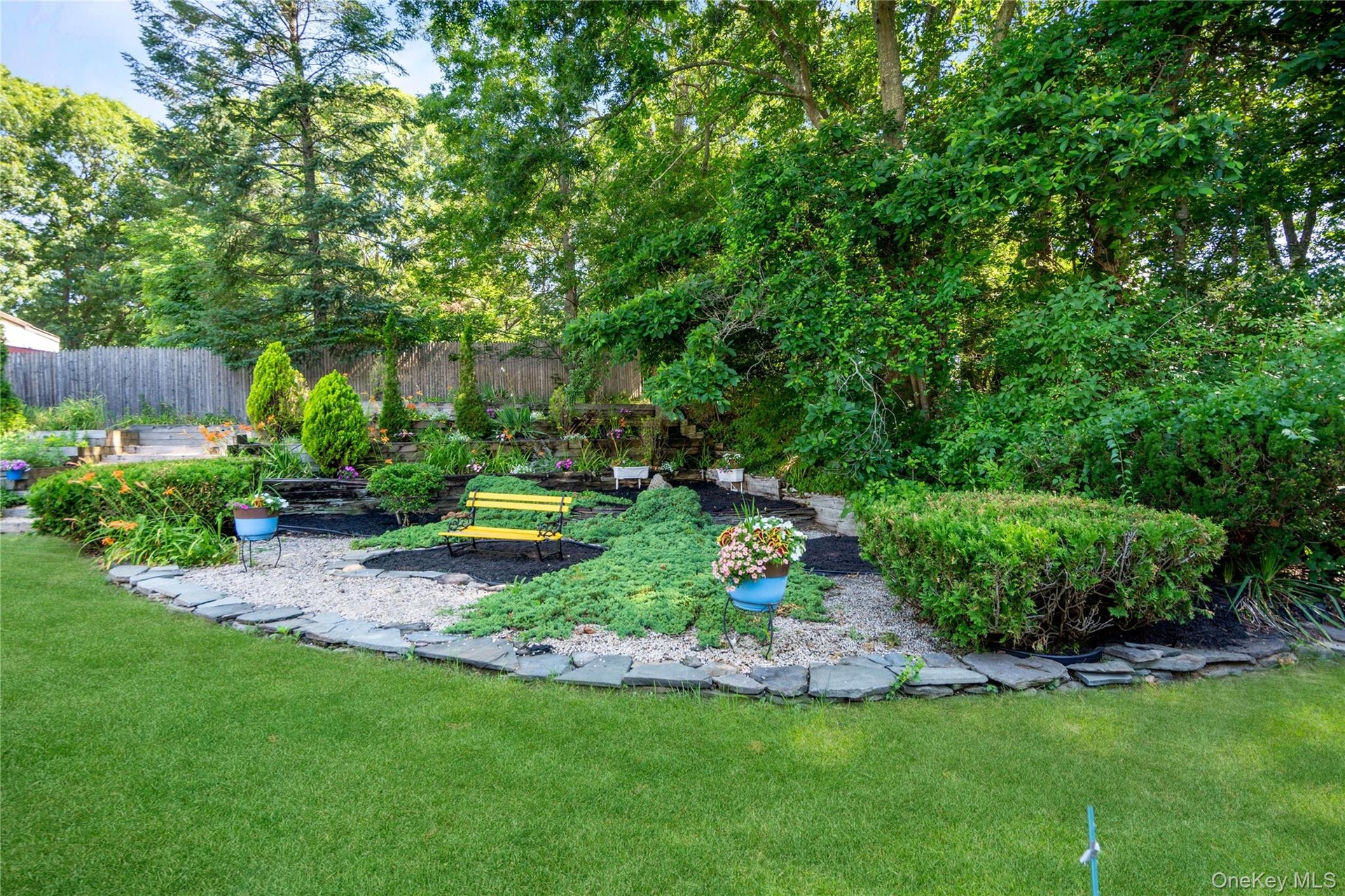 Koi pond with a three-level waterfall, full plumbing and filtration system, and a covered design complete with a dedicated viewing bench.