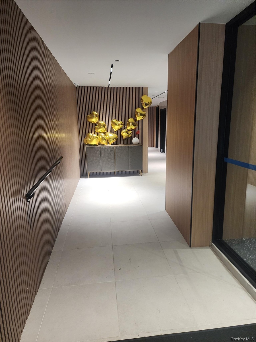 Wood-finish slatted wall panels, recessed lighting, and large format floor tiles
