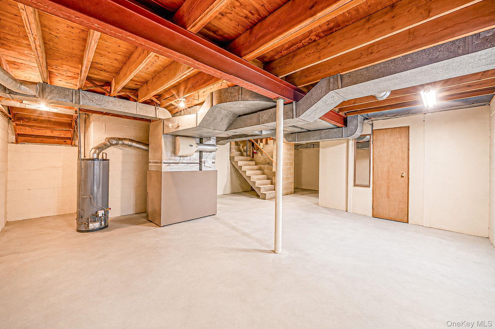 Unfinished basement with exposed ceiling joists, concrete flooring, and solid wood interior doors