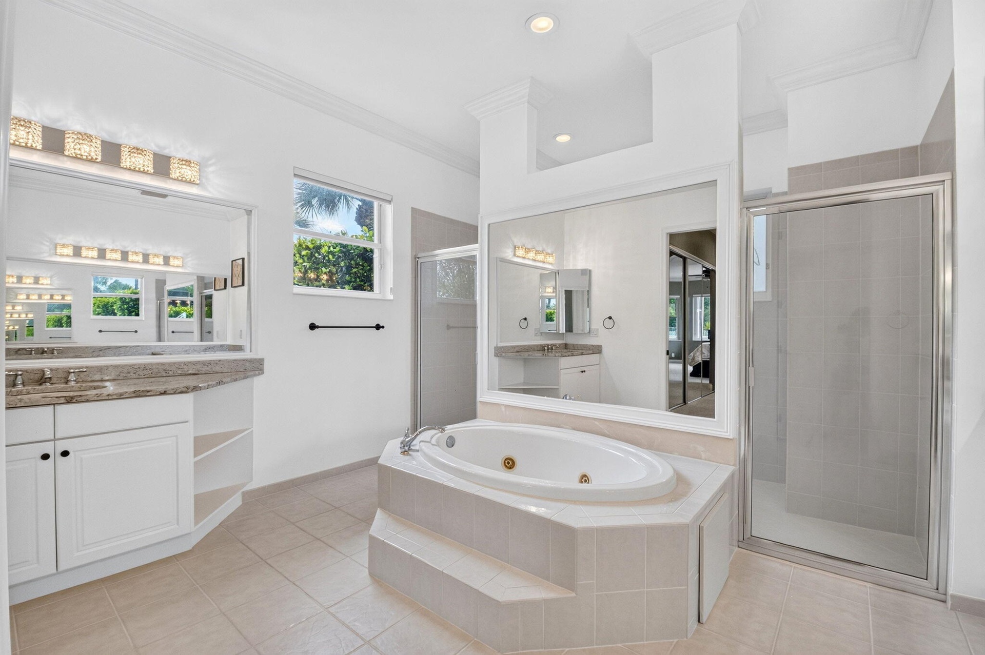 Dual vanity with granite-style countertop, white cabinetry, and undermount sinks