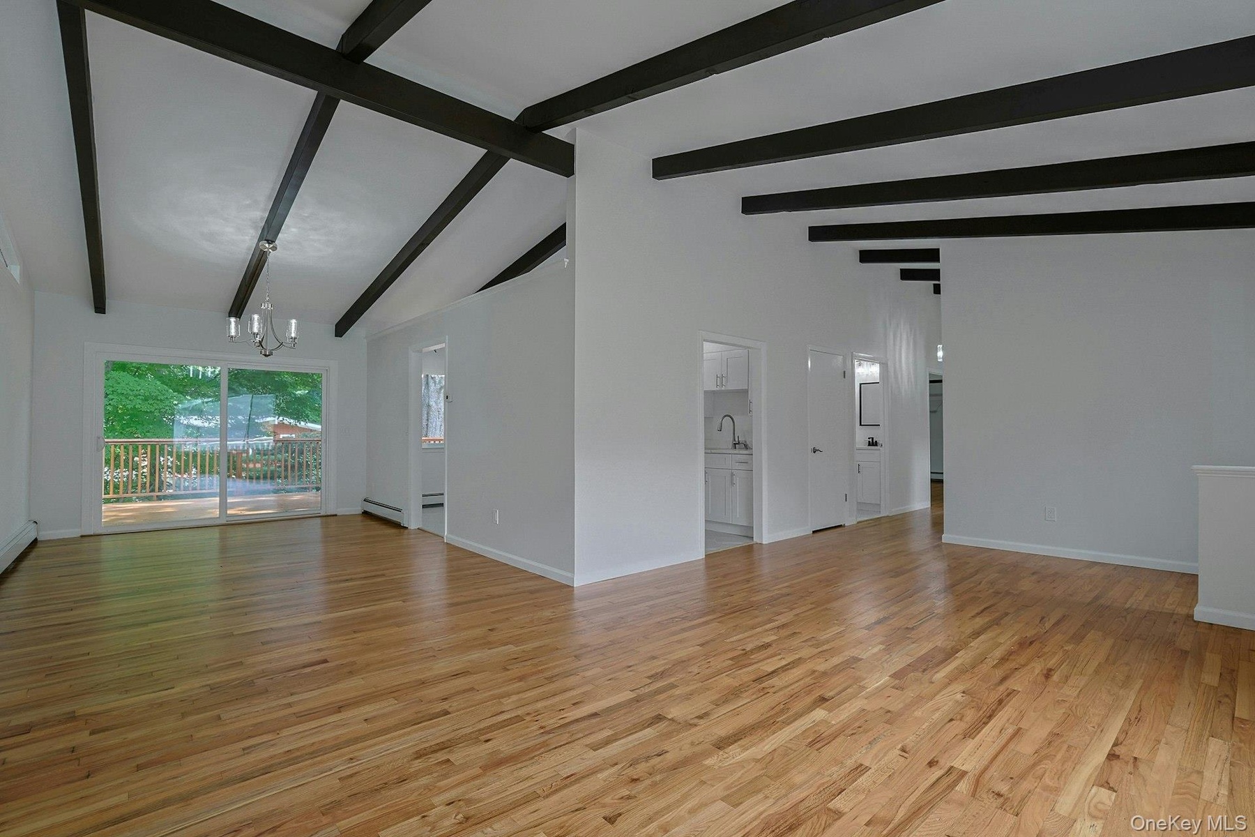 Living room looking into the dining room showing beamed cathedral ceiling