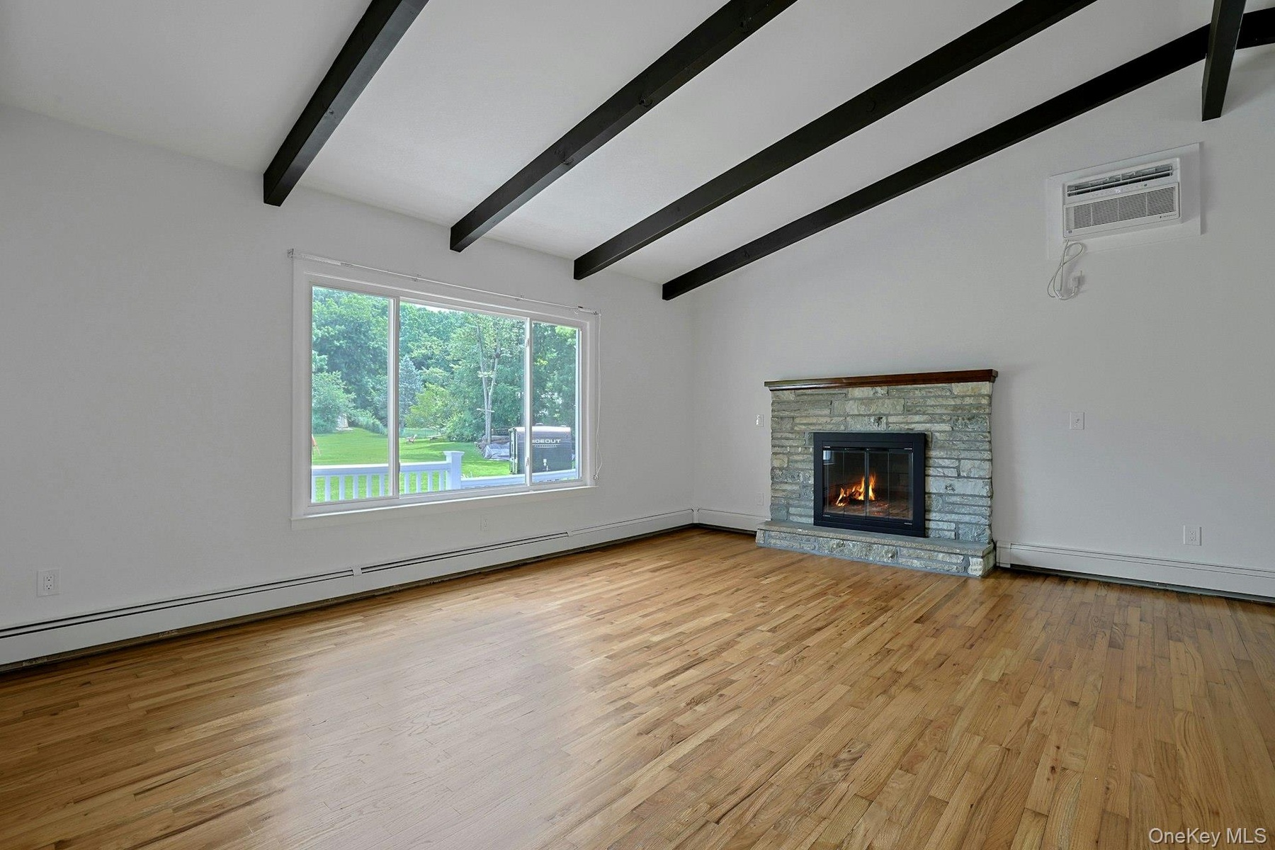 Another view of the living room featuring the large window for lots of natural light