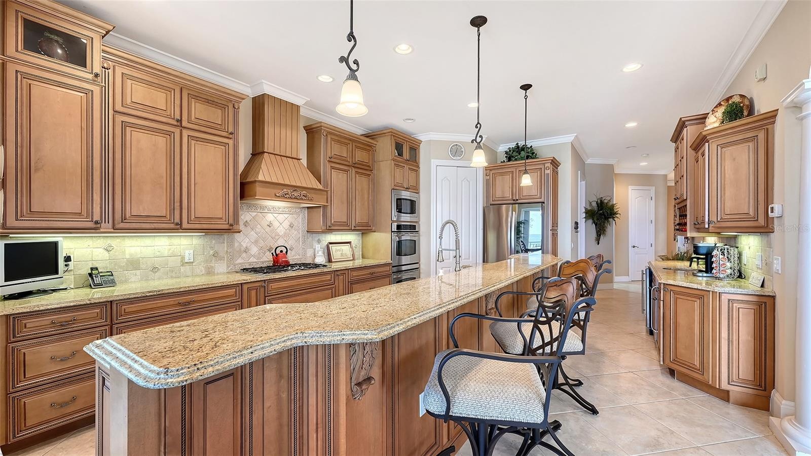 Gorgeous kitchen with wood cabinetry, granite counter tops, GE Profile and LG appliances. Gas stove, double oven, walk-in pantry is behind the white d